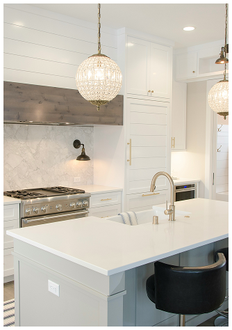 Bright modern kitchen with white cabinets, marble backsplash, and large island in a Port St. Lucie home