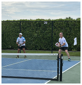 Two men playing pickleball on an outdoor court in Port St. Lucie community
