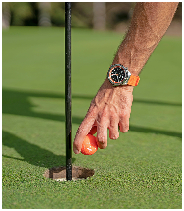 Golfer placing ball into hole on green at PGA Verano golf course in Port St. Lucie, Florida